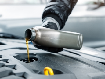 Persona poniendo aceite a un carro