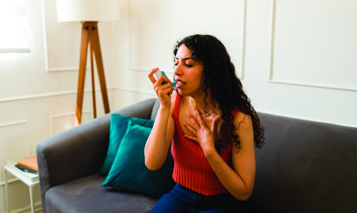 Mujer latina con un aparato para controlar el asma