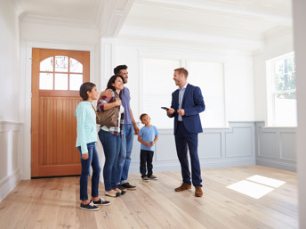 Familia latina viendo una casa nueva