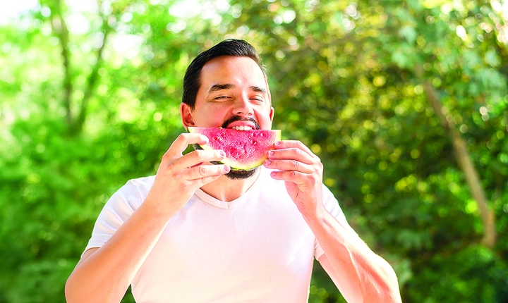 Hombre hispano comiendo sandía