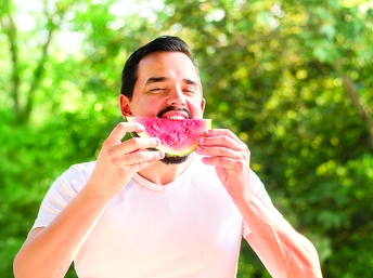 Hombre hispano comiendo sandía