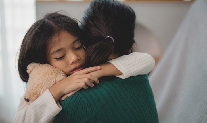 Niña llorando abraza a su mamá