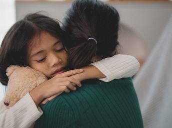 Niña llorando abraza a su mamá