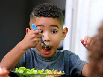 niño comiendo una ensalada