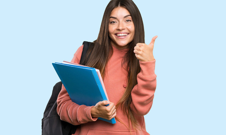 Joven mujer hispana sosteniendo una carpeta y levantando el pulgar de la otra mano