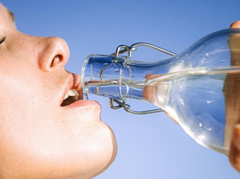 Mujer tomando agua en un día de verano