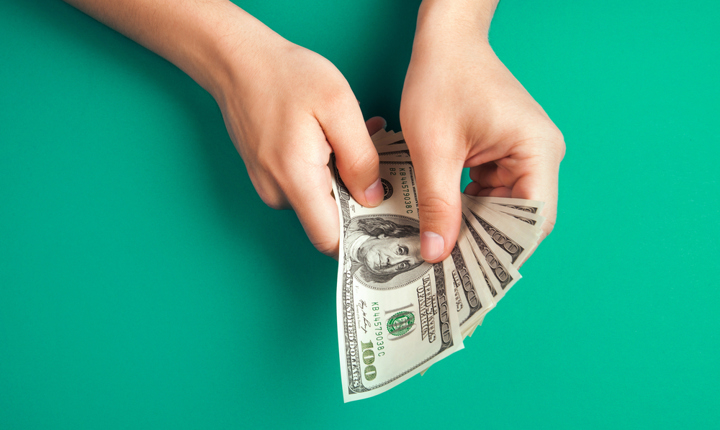 Manos con billetes de cien dólares