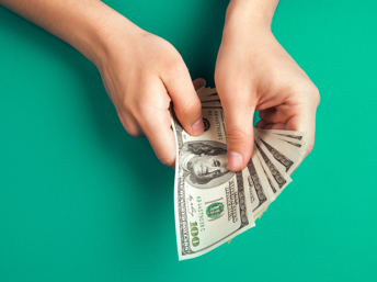 Manos con billetes de cien dólares