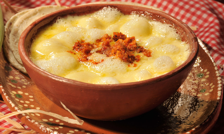 queso fundido con chorizo servido en un plato de barro