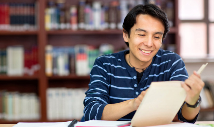 Estudiante latino leyendo un libro