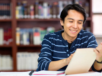 Estudiante latino leyendo un libro