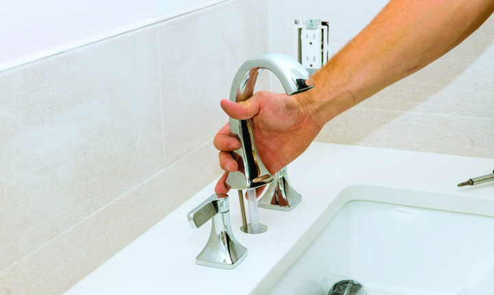 Persona instalando una llave de agua del baño