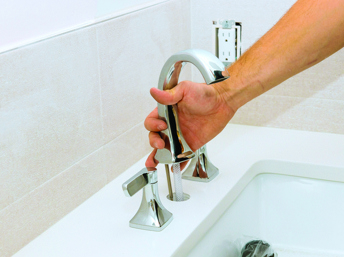 Persona instalando una llave de agua del baño