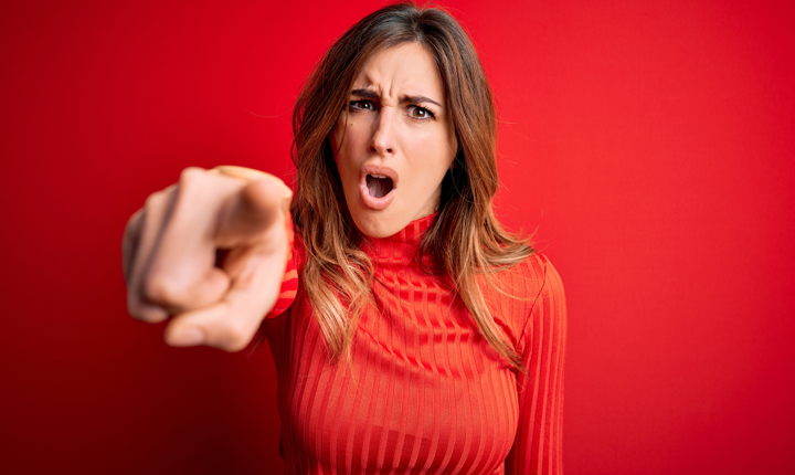 Chica de rojo en actitud de culpar a alguien
