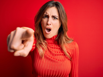 Chica de rojo en actitud de culpar a alguien