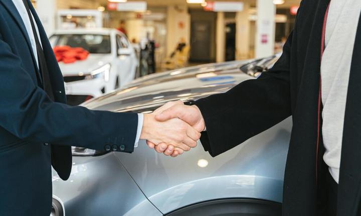 Comprador y vendedor cerrando la venta de un carro