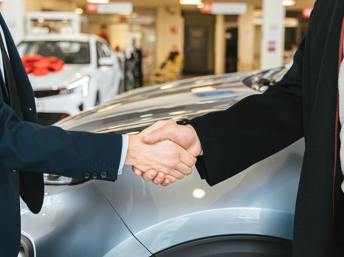 Comprador y vendedor cerrando la venta de un carro