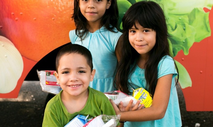 Niños latinos con alimentos entregados de forma gratuita