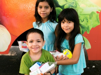 Niños latinos con alimentos entregados de forma gratuita