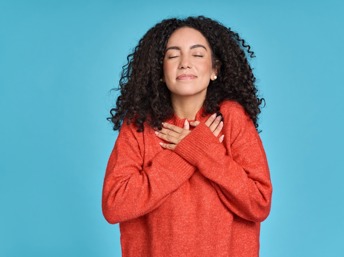 Chica latina con suéter rojo en actitud de sentirse feliz con la vida