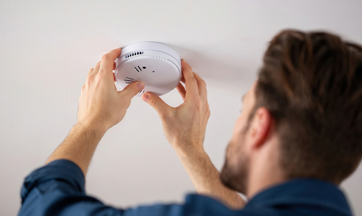 Persona instalando un detector de humo