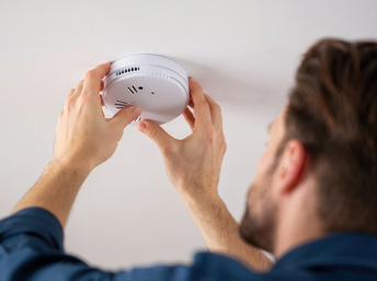 Persona instalando un detector de humo