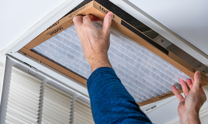 persona cambiando un filtro de aire en el hogar