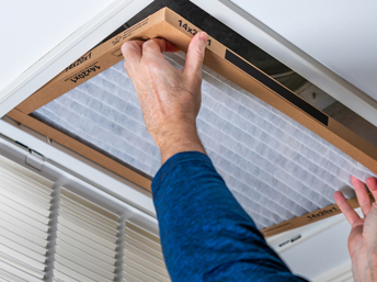 persona cambiando un filtro de aire en el hogar