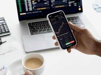 Persona usando sus dispositivos para invertir en la bolsa