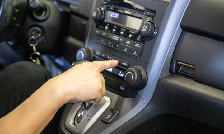 Mecánico en California usando el aire acondicionado de un carro durante el verano, como parte de una nota sobre el programa Cool Air Rebate que ayuda a reparar el aire acondicionado de vehículos elegibles.