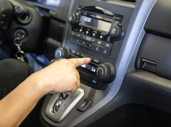Mecánico en California usando el aire acondicionado de un carro durante el verano, como parte de una nota sobre el programa Cool Air Rebate que ayuda a reparar el aire acondicionado de vehículos elegibles.